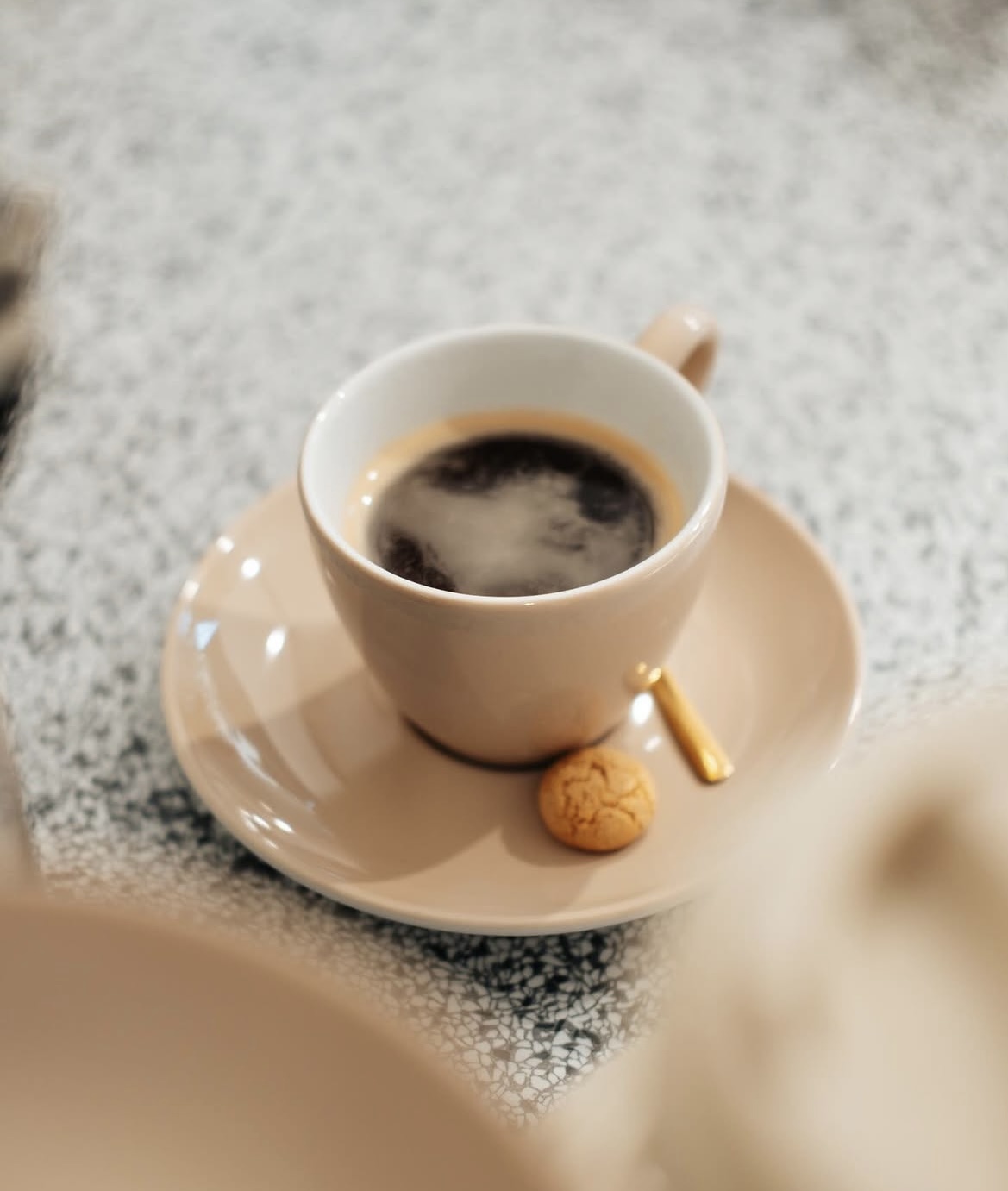 Espresso in een beige kopje met koekje