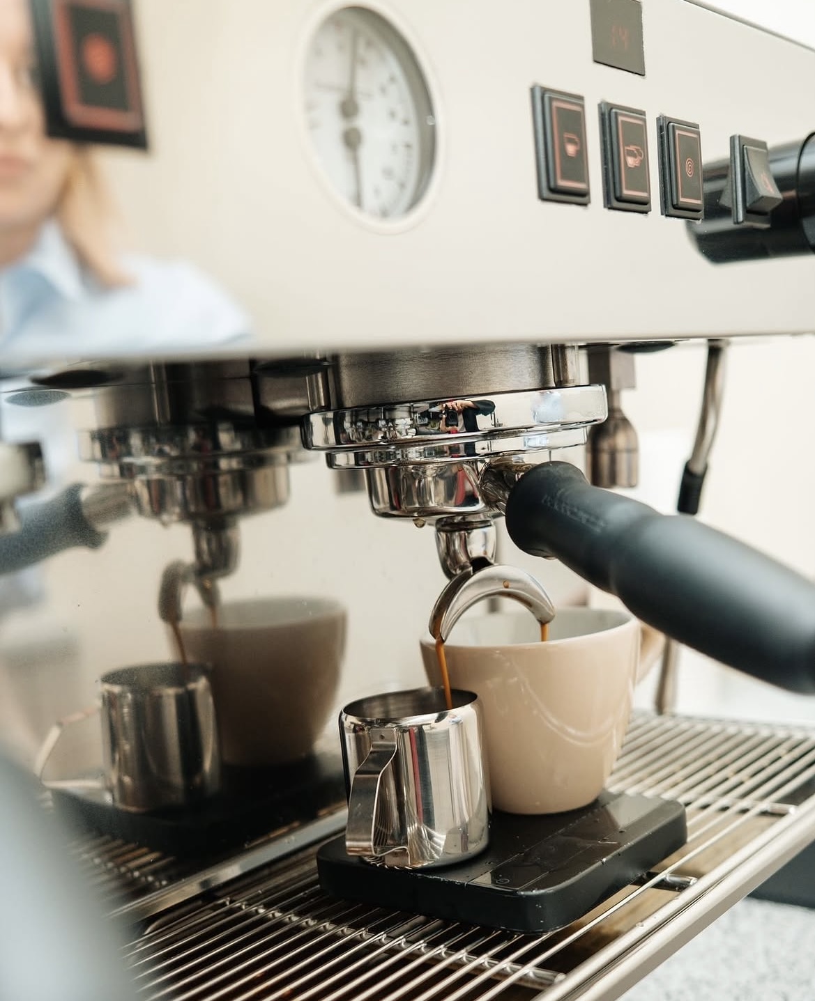 Espresso loopt uit de machine in een beige kopje